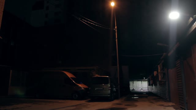 Garages And Parked Next Car. Night Lighting Of The Lamp