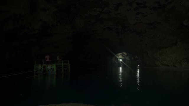 Several People Float On A Raft On The Lake Inside A Cave