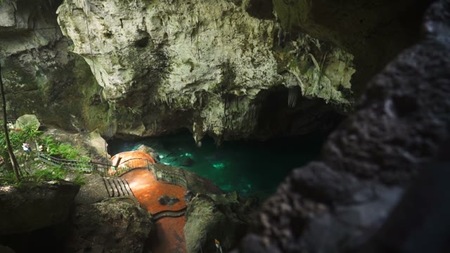 The Camera Takes A Cave With A Pond And A Beautiful Staircase