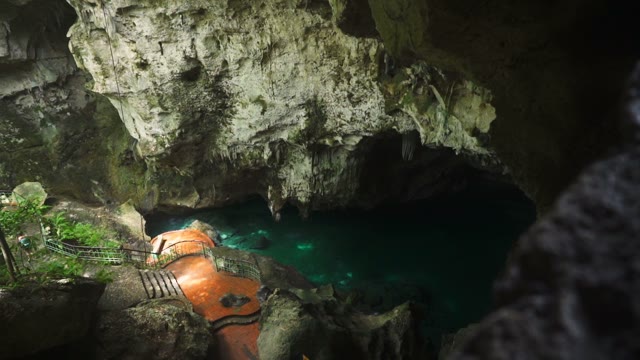 The Camera Takes A Deep Cave With A Pond And Staircase