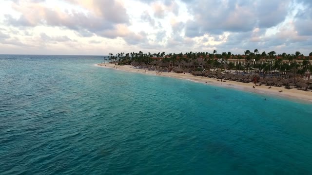 The Camera Flies Over The Sea Along The Sandy Beach