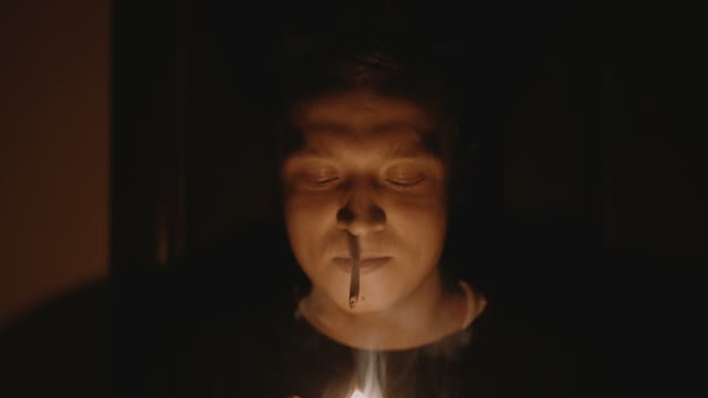 Man Ignites A Cigarette In Pitch Darkness Close-up