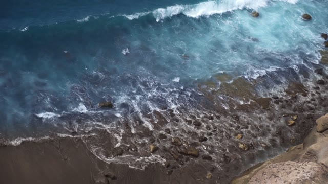 Blue Sea Waves Beat Against The Stone Beach