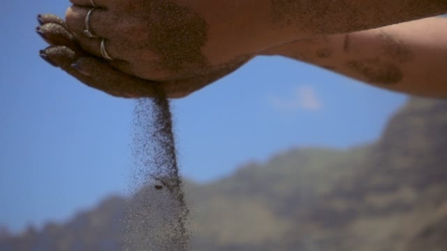 Woman Pours Sand Palms