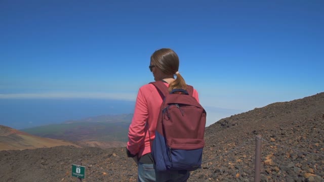 Girl With A Backpack Standing On Top Of A Mountain