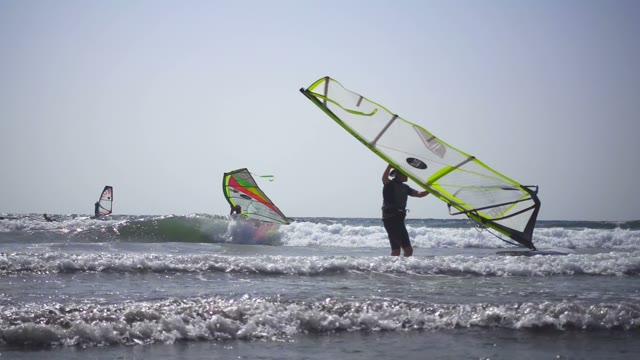 Surfers Come Out Of The Sea