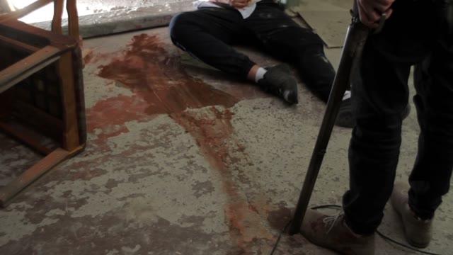Men With A Shotgun Moving Away From The Wounded Man Close-up