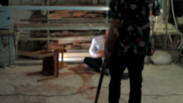 Man With A Gun Close To Wounded Man