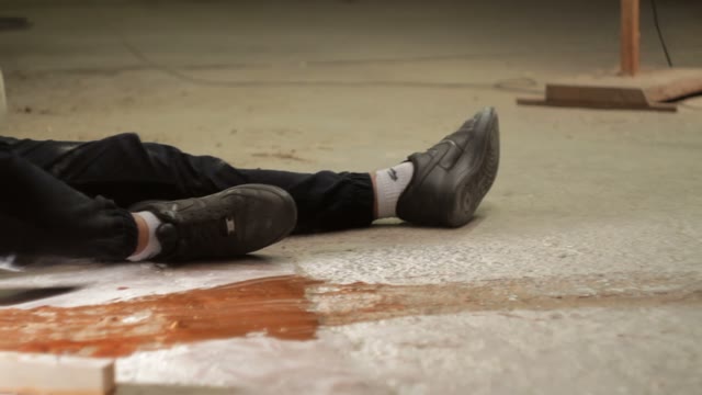 Man With A Gun Coming To A Wounded Man