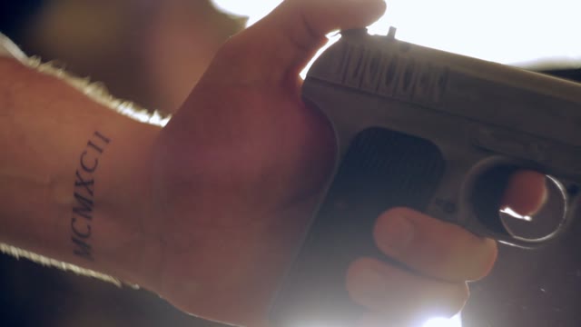 Man Cocks The Gun And Shoots Close-up