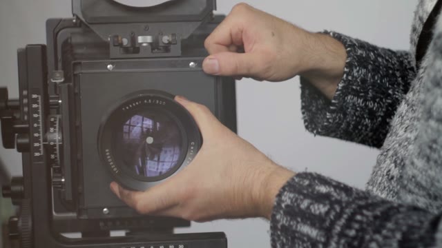 Man Removes Camera Lens Close-up