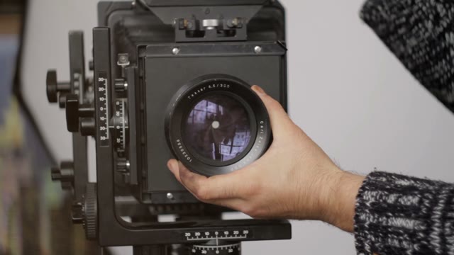 Man Holding A Camera Lens Close-up