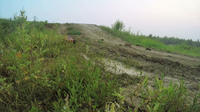 Radio-controlled Machine Rides On The Puddle. Spray Are Flying Into The Camera