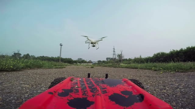 RC Cars With A Camera Rides On The Dirt Road And Filmed The Quadrocopter, Flying
