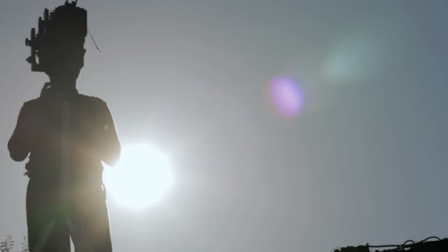 Silhouette Of A Man Adjusts The Retro Camera
