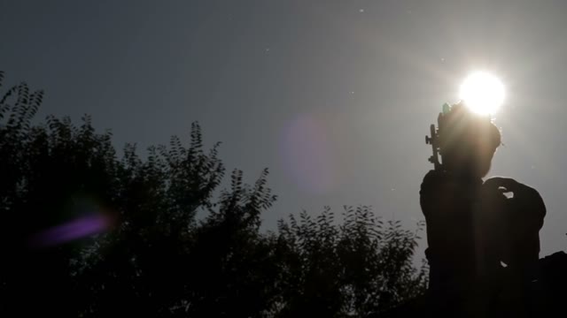 Silhouette Of A Man Adjusts The Retro Camera