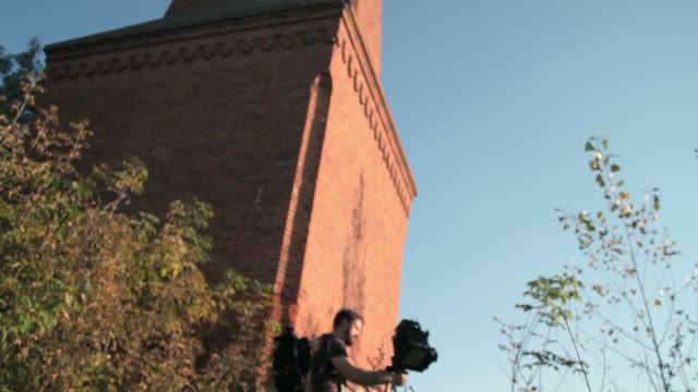 Man Sets Retro Camera Next To The Chimney