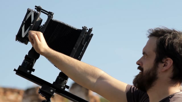Man Adjusts The Retro Camera Close-up