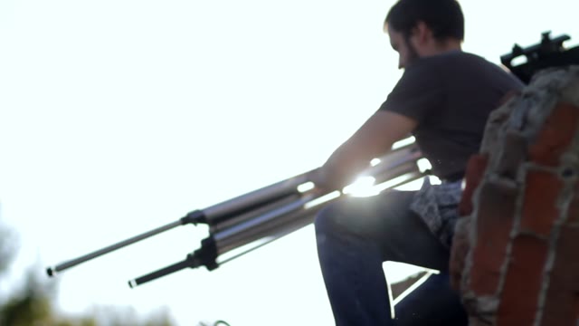 Man Carries Retro Camera To Another Location