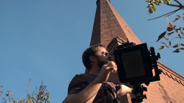 Man Sets Retro Camera Next To The Chimney