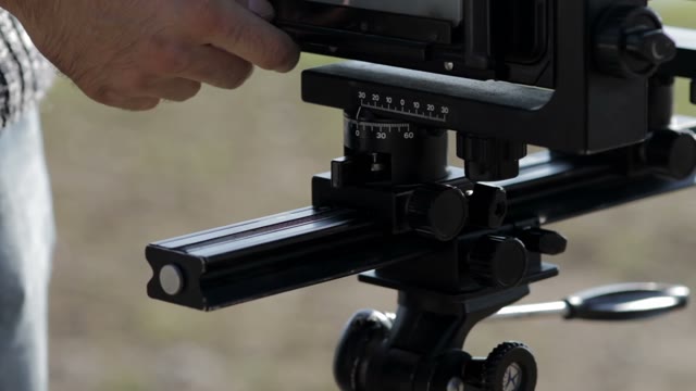 Man Adjusts The Retro Camera Close-up