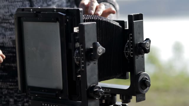 Man Adjusts The Retro Camera Close-up