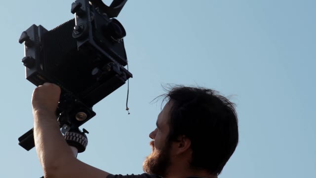 Man Adjusts The Retro Camera Close-up