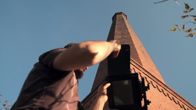 Man Sets Retro Camera Next To The Chimney