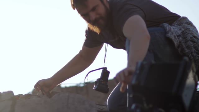 Man Carries Retro Camera To Another Location