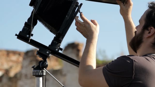 Man Adjusts The Retro Camera Close-up