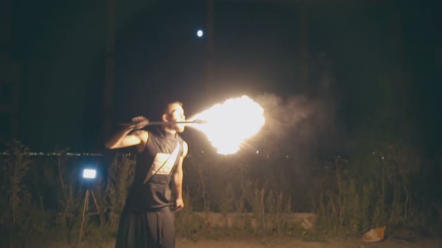 Adult Muscular Guy Breathes Fire At Night
