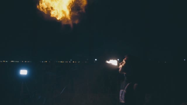 Young Muscular Guy Breathes Fire At Night