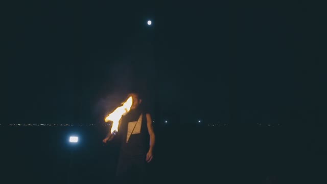 Brave Muscular Guy Breathes Fire At Night