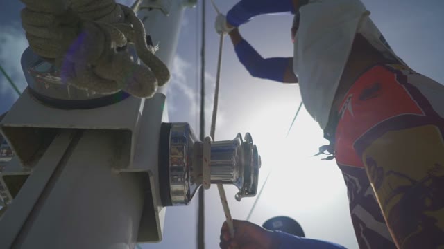 The Man Pulls The Rope For The Sails In A Sunny Day