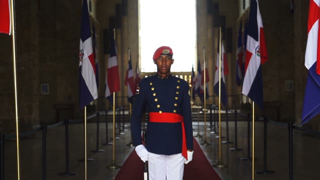 A Young Soldier Stands Between The Dominican Flag