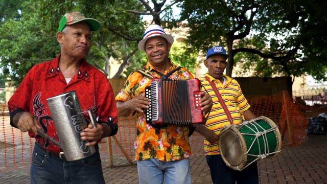 Three Adults Musician Singing And Playing Outdoors