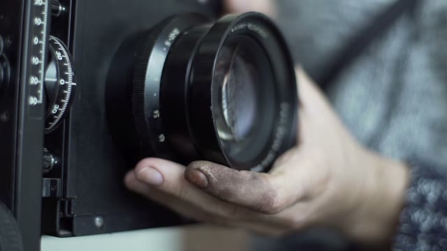 Man Removes The Lens With An Retro Camera Close-up