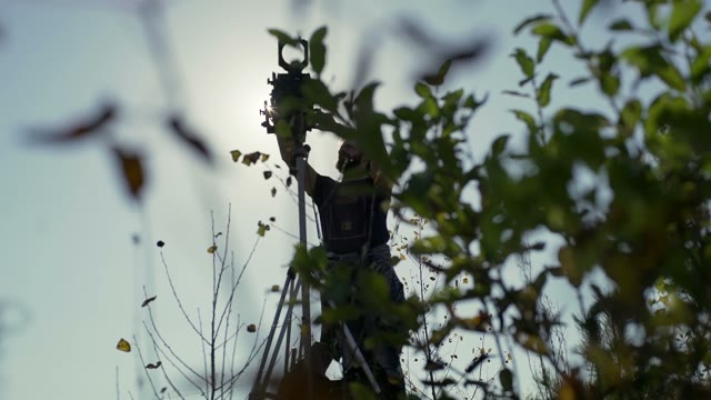 Man Sets A Retro Camera Among Green Bushes