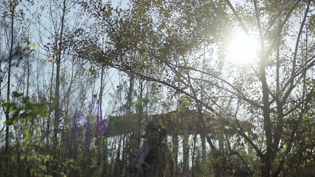 Man Walks With A Retro Camera Among Green Trees