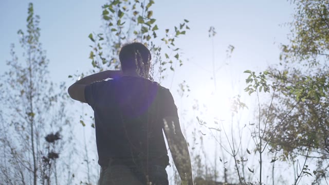 Man Puts A Retro Camera Among Green Trees