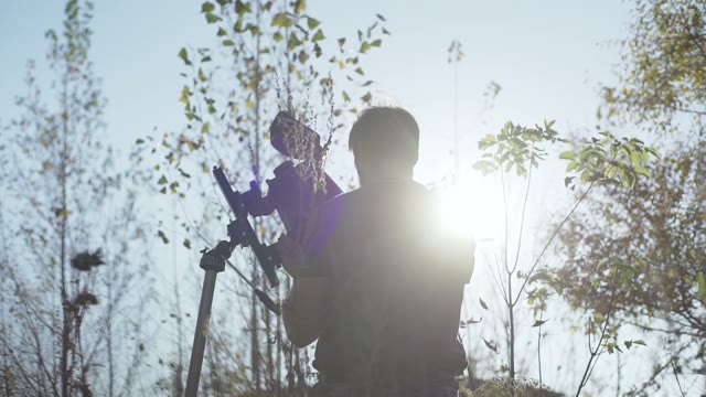 Man Puts A Retro Camera Among Green Trees