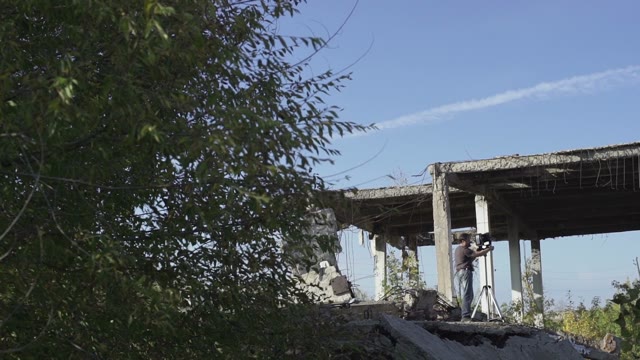Man With Retro Camera Among The Ruins