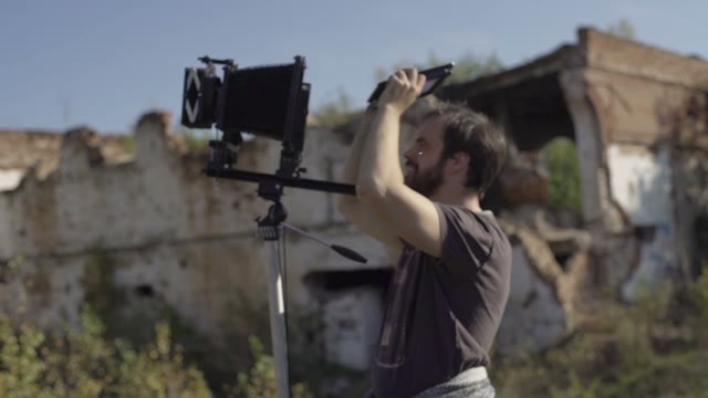 Man With Retro Camera Among The Ruins