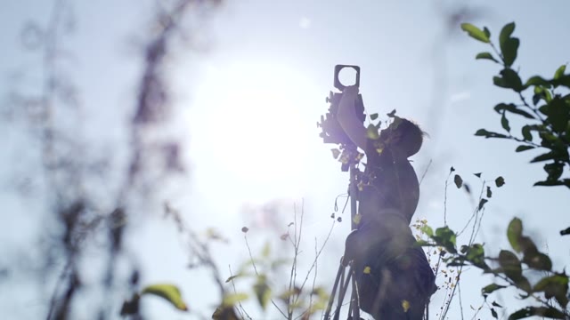 Man Sets Retro Camera Among Green Bushes