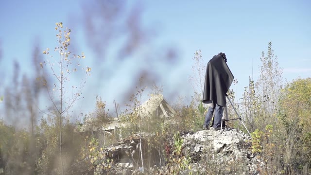 Man Photographs On Retro Camera Among The Ruins