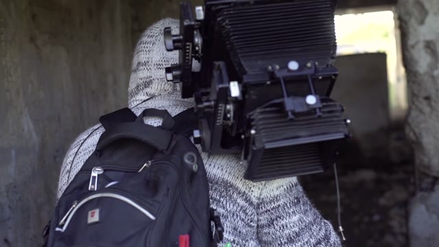 Man Walks With Retro Camera On The Abandoned Building