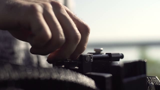 Man Sets Retro Camera. Close-up Of Hands