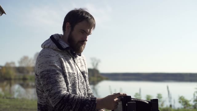 Man Sets Retro Camera Near The Lake Close-up