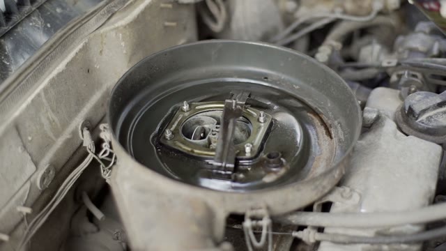 Man Sprinkles Car Engine Close-up