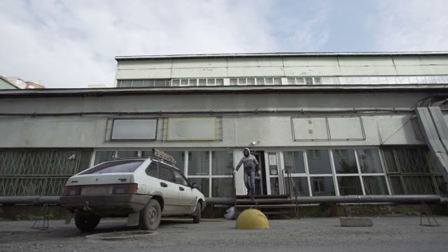 Man Comes Out Of The Building, And Sits In A Car